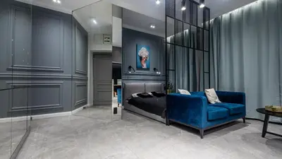 a bedroom with a blue bed and a blue couch at Glamour Jacuzzi Apartment in Kraków