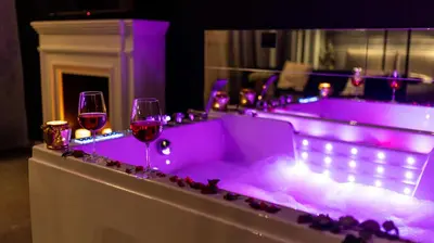 a purple bathtub with two glasses of wine at Glamour Jacuzzi Apartment in Kraków