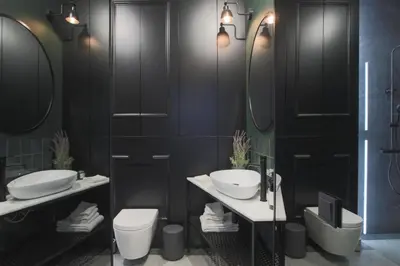 a bathroom with two sinks and a toilet and mirrors at Glamour Jacuzzi Apartment in Kraków