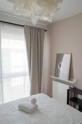 a bedroom with a white bed and a window at Aparthotel Weissa 7 in Kraków