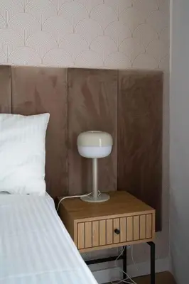 a bedroom with a bed and a nightstand next to a bed sidx sidx sidx at Aparthotel Weissa 7 in Kraków