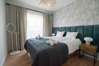 a bedroom with a bed with two towels on it at Aparthotel Weissa 7 in Kraków
