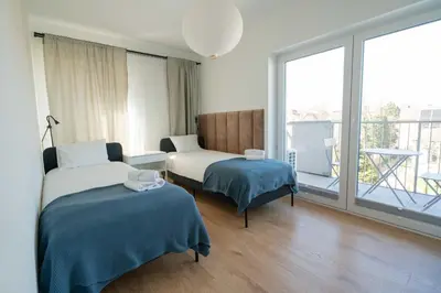 a hotel room with two beds and a balcony at Aparthotel Weissa 7 in Kraków