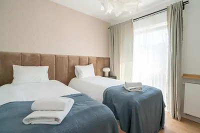 a bedroom with two beds and a window at Aparthotel Weissa 7 in Kraków