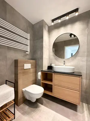 a bathroom with a sink and a toilet and a mirror at Aparthotel Weissa 7 in Kraków