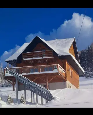 a log cabin in the snow with snow at Gorczańska Chata z tarasem widokowym in Poręba Wielka