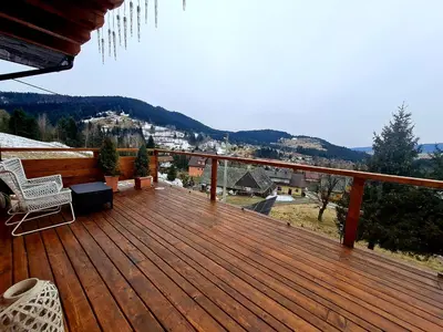 a wooden deck with a view of the mountains at Gorczańska Chata z tarasem widokowym in Poręba Wielka