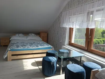 a bedroom with a bed and a table and stools at Apartament Kristel Zator in Podolsze