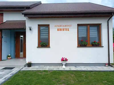 a white building with a sign on the side of it at Apartament Kristel Zator in Podolsze