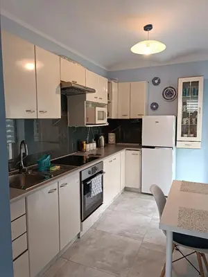 a kitchen with white cabinets and white appliances at Apartament Kristel Zator in Podolsze