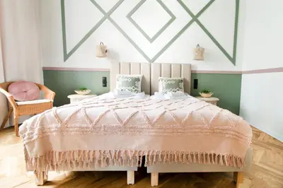 a bedroom with a large bed with a pink comforter at Modern Apartments Piłsudskiego Street in Kraków