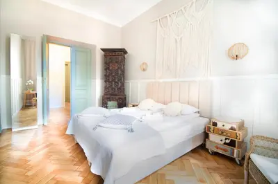 two beds in a bedroom with white walls and wooden floors at Modern Apartments Piłsudskiego Street in Kraków