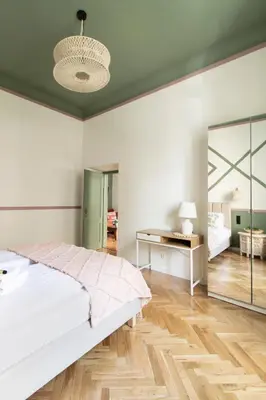 a white bedroom with a bed and a mirror at Modern Apartments Piłsudskiego Street in Kraków