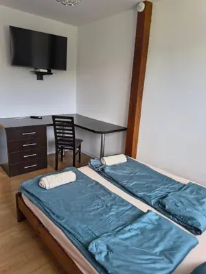 a bedroom with a bed and a desk and a television at Pokoje Kraków Tyniec Hostel in Kraków