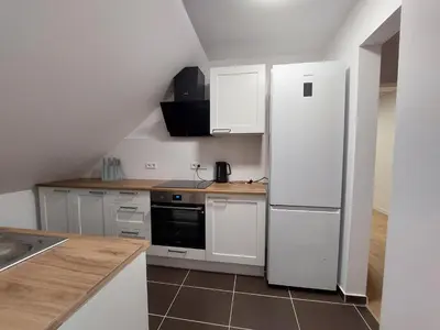 a kitchen with white cabinets and a refrigerator at Pokoje Kraków Tyniec Hostel in Kraków