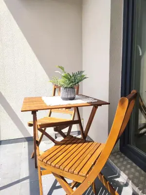 a wooden table and chair with a plant on it at Mogilska 120D by Homeprime in Kraków