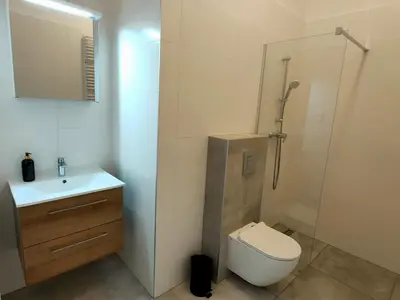 a bathroom with a toilet and a sink and a shower at Hugo Eden Apartments in Kraków