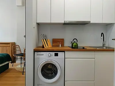 a kitchen with a washing machine and a sink at Hugo Eden Apartments in Kraków