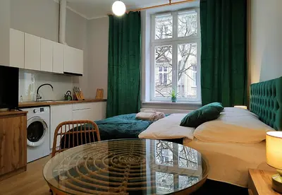 a living room with a bed and a glass table at Hugo Eden Apartments in Kraków