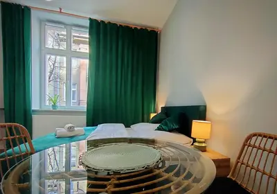 a room with a table and a green curtain at Hugo Eden Apartments in Kraków