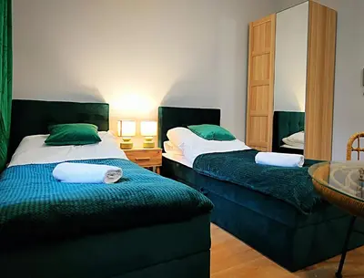 a bedroom with two beds with green and white at Hugo Eden Apartments in Kraków
