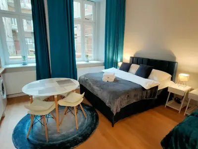a bedroom with a bed and a table and chairs at Hugo Eden Apartments in Kraków