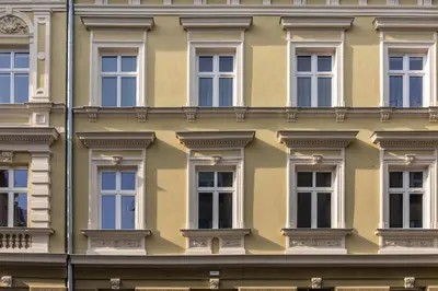 a row of windows on a yellow building at Felicjanek 15 - by Upstairs in Kraków