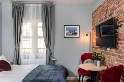 a small bedroom with a bed and a kitchen at Felicjanek 15 - by Upstairs in Kraków