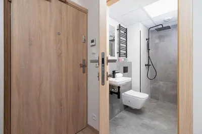 a bathroom with a toilet and a sink and a shower at Śródmieście Kątowa Air-conditioned Studio Kraków by Noclegi Renters in Kraków