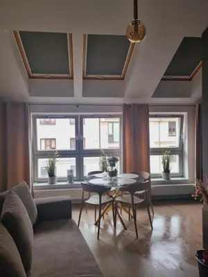 a living room with a table and some windows at Apartament Miodowa Street PARKING FREE in Kraków