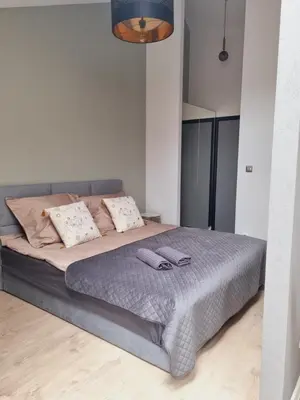 a bedroom with a large bed with two slippers on it at Apartament Miodowa Street PARKING FREE in Kraków