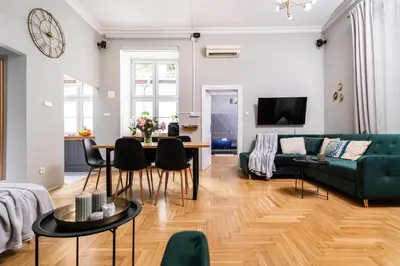 a living room with a green couch and a table at Old Town Luxury Apartment - Rynek Szewska in Kraków