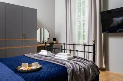 a bedroom with a blue bed with a tray of food at Old Town Luxury Apartment - Rynek Szewska in Kraków