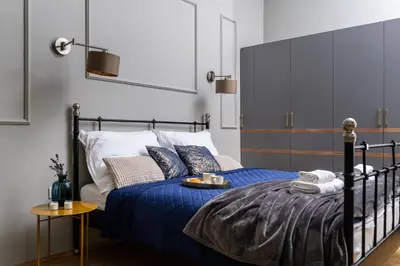 a bedroom with a bed with blue sheets and pillows at Old Town Luxury Apartment - Rynek Szewska in Kraków