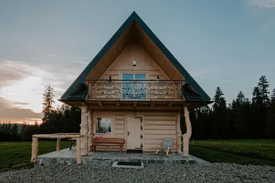a small cabin with a balcony on top of it at Domek pod lasem in Klikuszowa