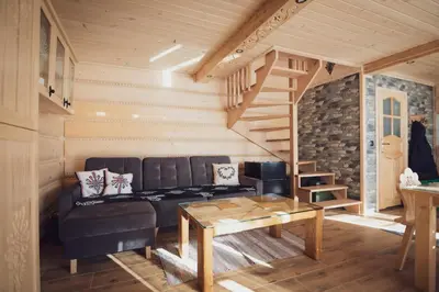 a living room with a couch and a table at Domek pod lasem in Klikuszowa