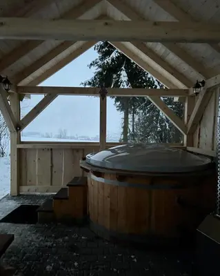 a hot tub in a pavilion with a wooden roof at Domek pod lasem in Klikuszowa