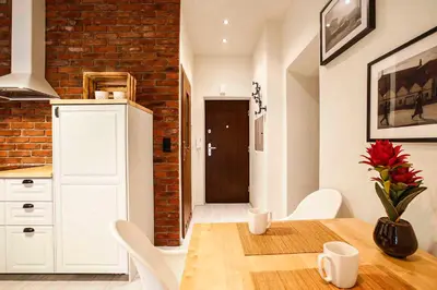 a kitchen with a table and a brick wall at 2-room Apartment with kitchen, heart of Cracow Old Town in Kraków