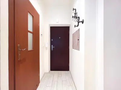 a hallway with a black door and a wooden floor at 2-room Apartment with kitchen, heart of Cracow Old Town in Kraków