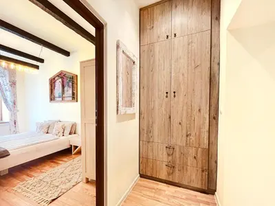 a room with a wooden closet and a couch at 2-room Apartment with kitchen, heart of Cracow Old Town in Kraków