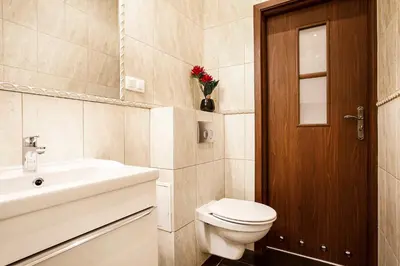 a bathroom with a toilet and a sink and a door at 2-room Apartment with kitchen, heart of Cracow Old Town in Kraków