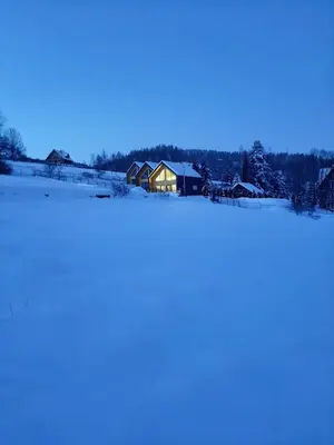 a house in the middle of a snow covered field at Beskidzkie Super Stodoły in Zawoja