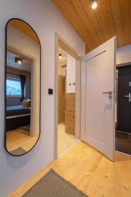 a mirror on the wall of a room with a bedroom at Beskidzkie Super Stodoły in Zawoja