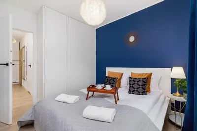 a bedroom with a large bed with a blue wall at Fredry 6 Apartment Premium Łagiewniki by Renters Prestige in Kraków