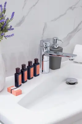 a row of bottles sitting on a bathroom sink at Fredry 6 Apartment Premium Łagiewniki by Renters Prestige in Kraków
