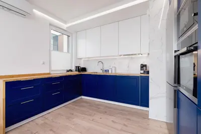a kitchen with blue cabinets and a window at Fredry 6 Apartment Premium Łagiewniki by Renters Prestige in Kraków