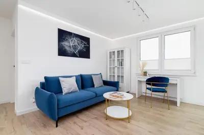 a living room with a blue couch and a table at Fredry 6 Apartment Premium Łagiewniki by Renters Prestige in Kraków