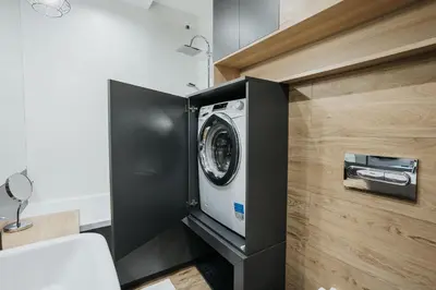 a washer and dryer in a black cabinet in a bathroom at Sky Mountain View Free Parking in Kraków
