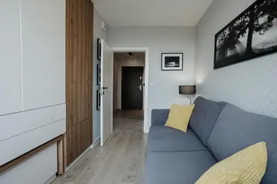 a living room with a blue couch and a hallway at Sky Mountain View Free Parking in Kraków