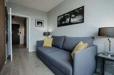 a living room with a blue couch with yellow pillows at Sky Mountain View Free Parking in Kraków